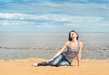 Fototapeta na wymiar Happy woman sitting on the beach