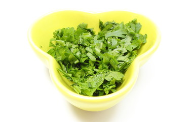 Fresh and natural chopped parsley in yellow dish.