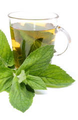 Fresh green mint and cup of beverage. White background
