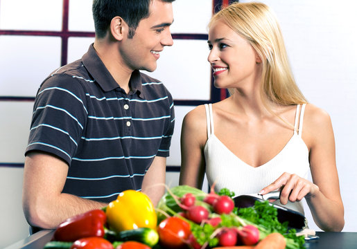 Young attractive happy smiling couple cooking