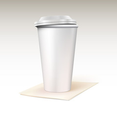 Paper cup for coffee standing on a napkin.
