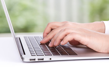 Closeup of business woman hand typing on laptop keyboard