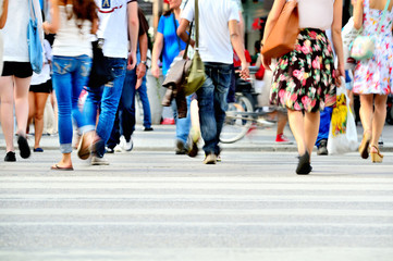 Motion blurred pedestrians crossing sunlit street