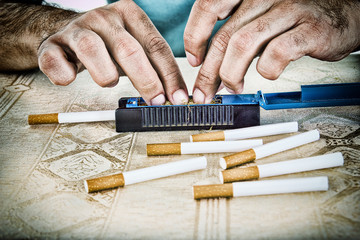 Hands of man making cigarettes