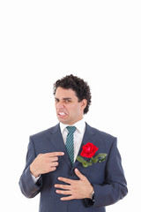 man in suit with disgust shows with his hand flower which is in