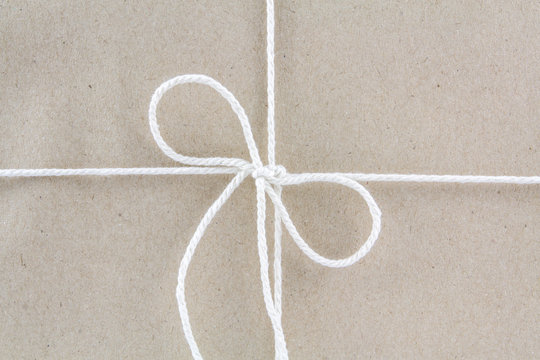 Tied in a bow on a brown recycled paper .package