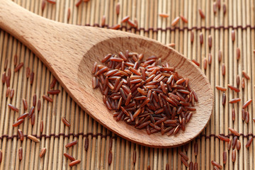 Red rice in a wooden spoon