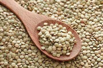 Green lentils in a wooden spoon