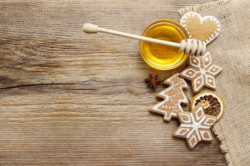 Gingerbread christmas cookies and bowl of honey on wooden table