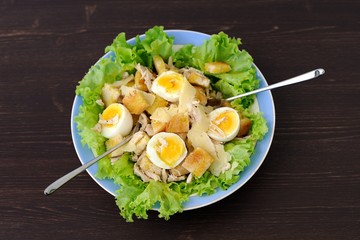 Salad Caesar with eggs and two forks