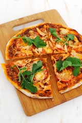 Arugula pizza on bamboo board