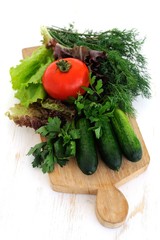 Green cucumbers, tomato and fresh herbs