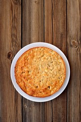 Old-fashioned apple pie on a wooden background