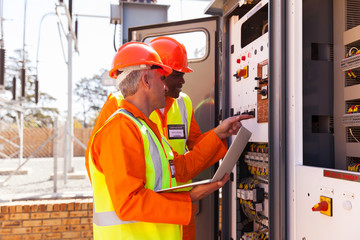 electrical engineers adjusting transformer settings