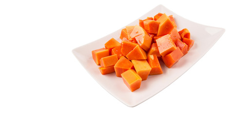 Bite sized papaya fruit on white plate over white background