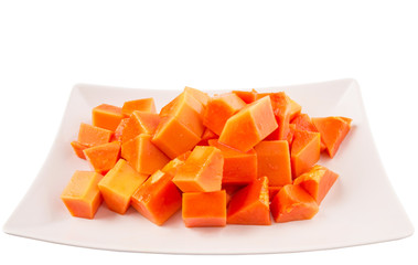 Bite sized papaya fruit on white plate over white background