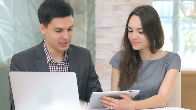 young attractive business man and woman discussing collating dat