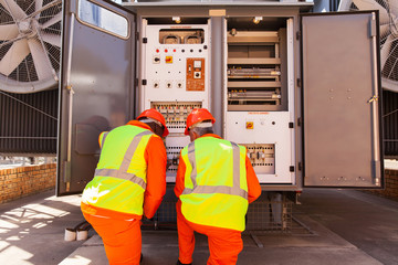 male electricians repairing transformer