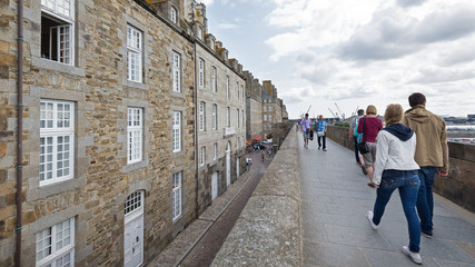 People walking on the walls of Saint Malo, France. - obrazy, fototapety, plakaty