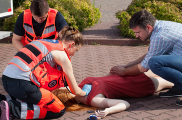 Couple of paramedics examining woman