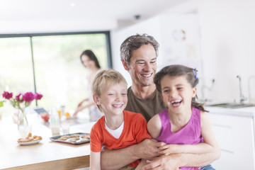 family in the kitchen at breakfast children on their father's la