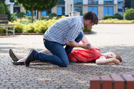 Man trying to help unconscious woman