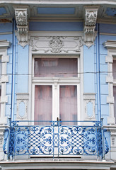 Ornate baroque window with a balcony in old blue building