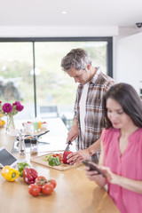 handsome couple in a kitchen, man at work and woman at phone