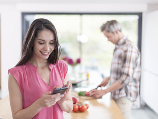 handsome couple in a kitchen, man at work and woman at phone