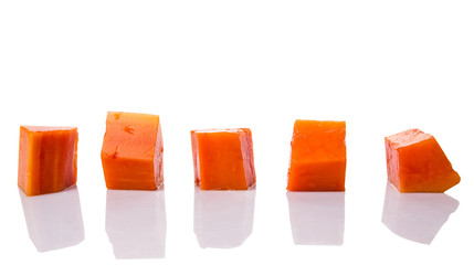 Bite sized papaya fruit over white background