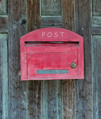 Red wooden mail box on wooden wall