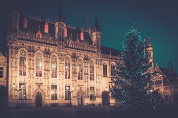 Fototapeta na wymiar Illuminated Christmas tree on a Burg square in Bruges, Belgium