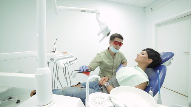 Dentist puts himself and girl lying in the dental chair protecti