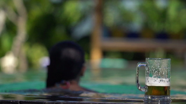 Beer glass by the pool, woman swim away, super slow motion, 240f