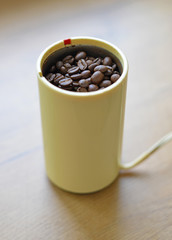 A blade or propeller coffee grinder on the table top.