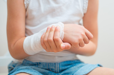 Child arm with gauze bandage on it.