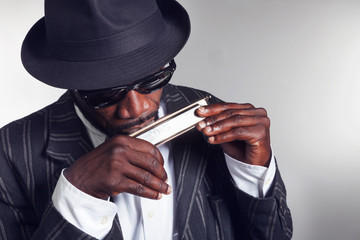 musician plays the harmonica - obrazy, fototapety, plakaty