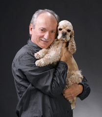 Smiling old man with a young american spaniel