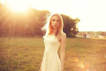Girl in the park in a white dress on a sunny day