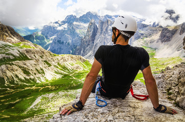 Climber on via ferrata Torre di Toblin, resting on the top