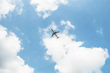 Airplane landing in bright sky