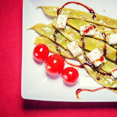 A plate of string beans with feta cheese and sesame seeds, decor