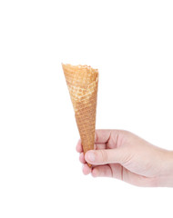 Hand holds empty ice cream corn.