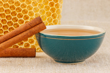 Honey in bowl with honeycomb and cinnamon © bbszabi