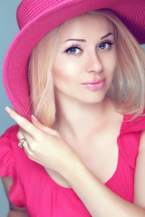 Beautiful blond woman with makeup, smiling girl posing in pink h
