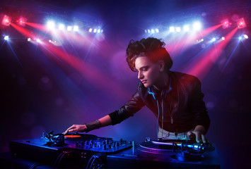 Teenager Dj mixing records in front of a crowd on stage