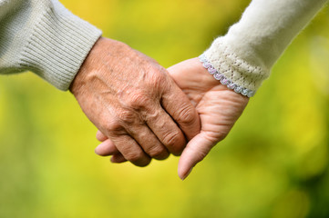 Elderly couple holding hands - Powered by Adobe