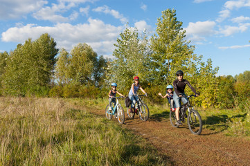 Active family on bikes cycling outdoors, with kids on bicycles