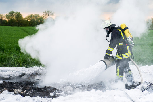 Feuerwehrmann bei L&ouml;scharbeiten mit Schaummittel