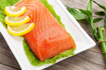 Fresh salmon fish with lemon and salad leaves